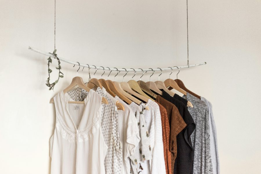 A curated rail of clothes on wooden hangers