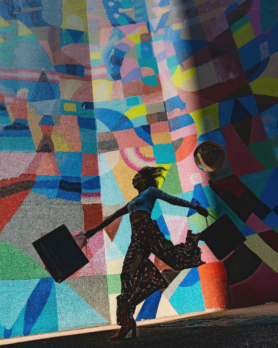 A woman walking past a colourful painted mural